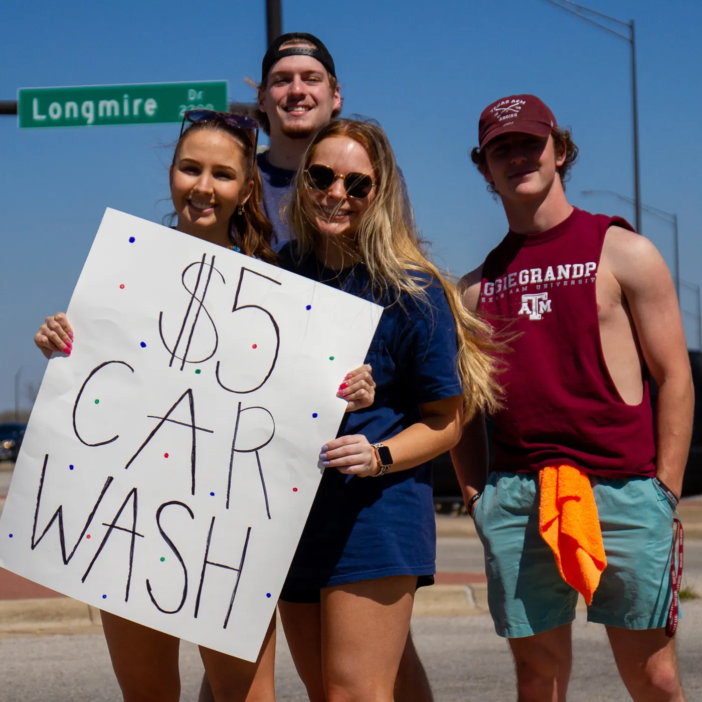 Members holding car wash signs